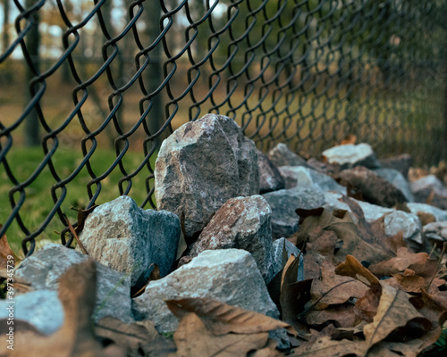 pile of rocks against fence