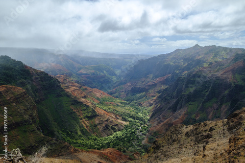 a landscape with hills and trees with Waimea Canyon State Park in the background © kingmauri