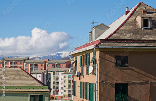 Edifici residenziali in una zona di campagna molto vicino alla città. Sullo sfondo, neve sulle montagne. 
