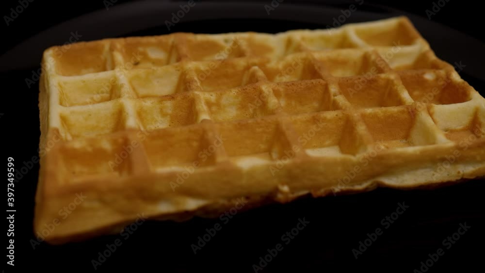 Freshly baked Belgian waffle with sugar - slow motion shot Freshly baked Belgian waffle with sugar - slow motion shot