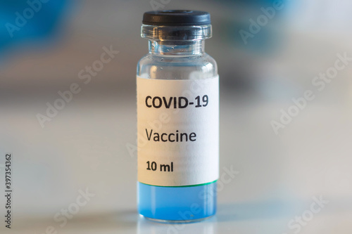 Concept of Covid 19 vaccine vaccinating, development and creation, doctor or scientist in laboratory holding a single dose of 2019-ncov vaccine, a syringe and ampule with SARS-CoV-2 vaccination