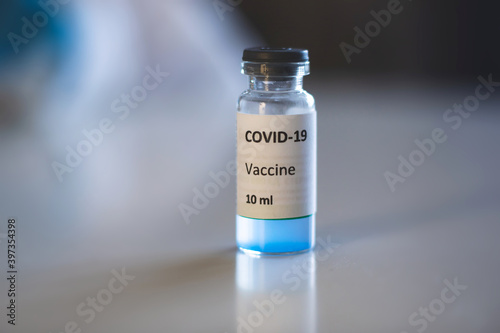 Concept of Covid 19 vaccine vaccinating, development and creation, doctor or scientist in laboratory holding a single dose of 2019-ncov vaccine, a syringe and ampule with SARS-CoV-2 vaccination