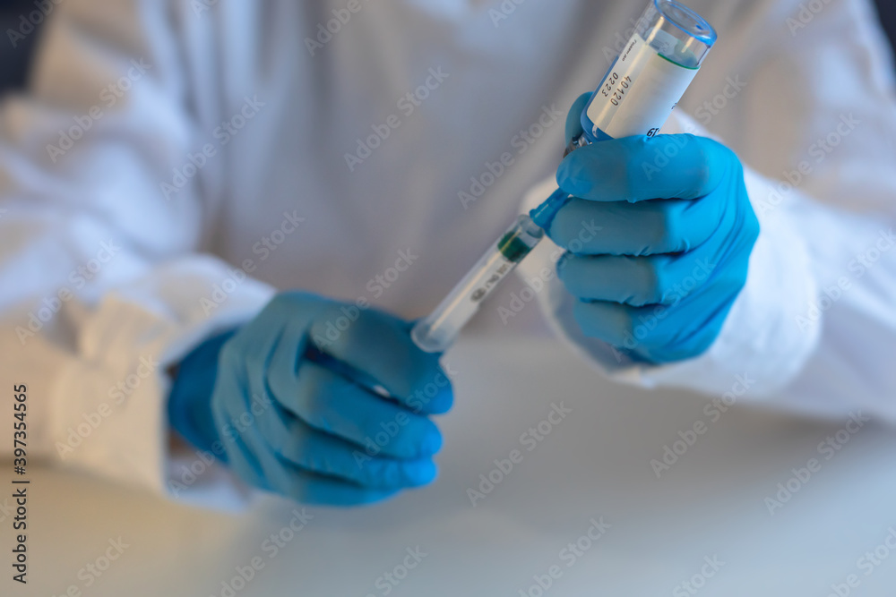 Concept of Covid 19 vaccine vaccinating, development and creation, doctor or scientist in laboratory holding a single dose of 2019-ncov vaccine, a syringe and ampule with SARS-CoV-2 vaccination Concept of Covid 19 vaccine vaccinating, development and creation, doctor or scientist in laboratory holding a single dose of 2019-ncov vaccine, a syringe and ampule with SARS-CoV-2 vaccination
