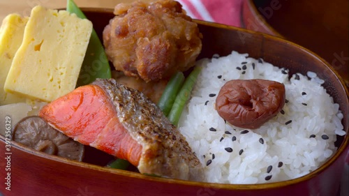 japanese style bento in wooden box with salmon and fried chicken