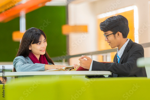 Advertising, Education, Business Concept - Group of Asian Businessman and Asian Businesswoman reading a book in the library.