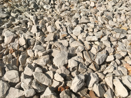 Small rock stone fence grey. Natural stones for construction and exterior design. Grey and white stone background