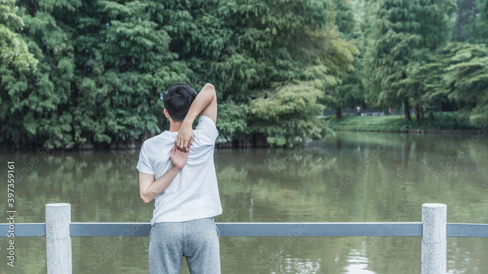 Young man stretching body at the lakeside Young man stretching body at the lakeside