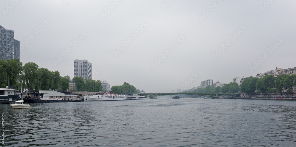 View of the Mirabeau Bridge. On the river Seine ships sail, some moored in the port