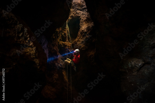 Rescuers or climber descends in a cave fast rope in the dark caves