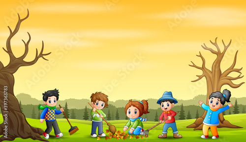 Cute volunteers kids cleaning up autumn leaves in the park