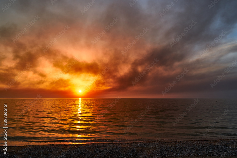 Obraz premium Sea sunset. Smoke wildfires sweeping across the sky.