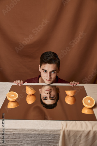 model man at table with oranges and fabric background