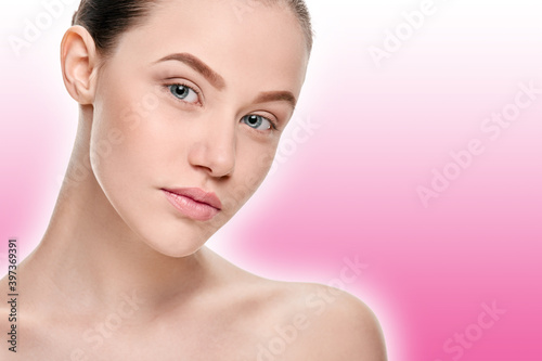 Beautiful young woman with fresh healthy facial skin on a pink background with a shaded white outline