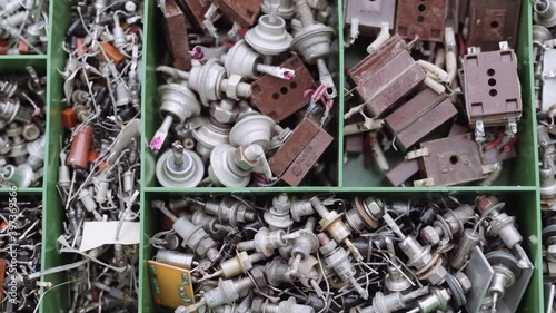 A box with a variety of radio components. A scattering of various old radio parts transistor resistor diode.
