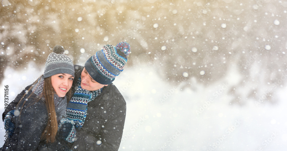 Loving couple in wool hats embracing in the winter forest Loving couple in wool hats embracing in the winter forest