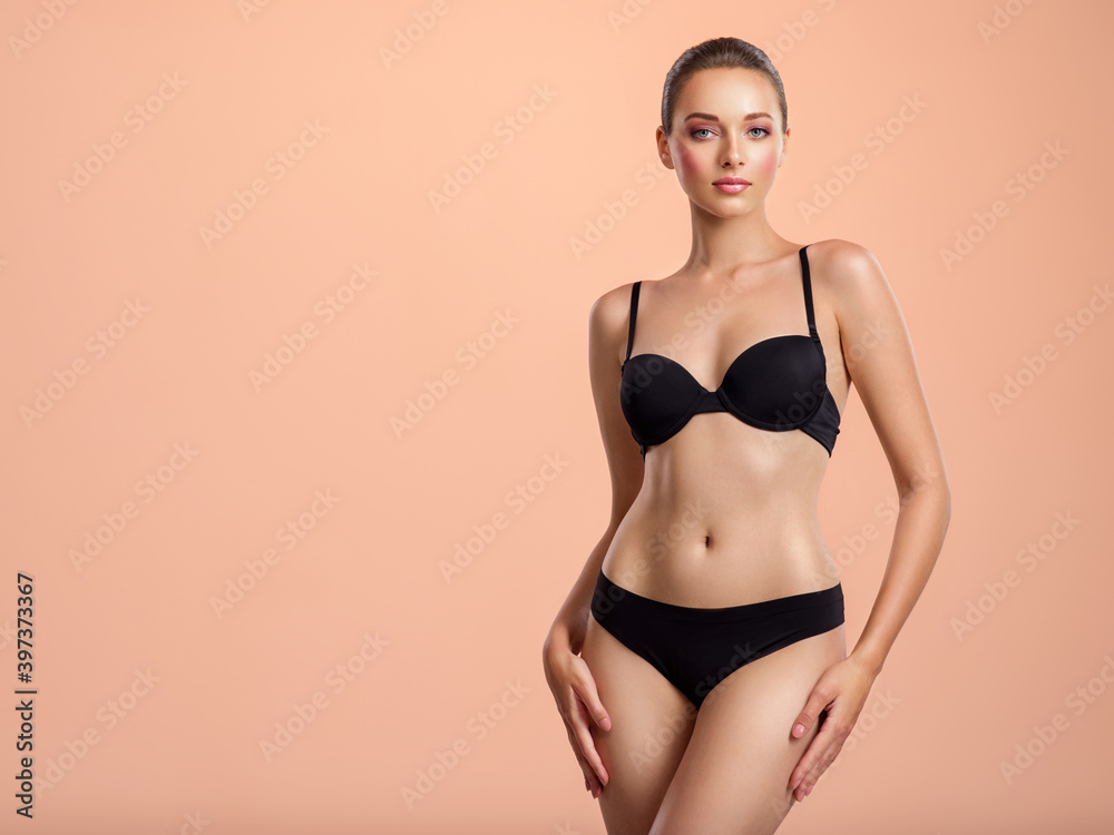 Young girl in black underwear with an ideal body, posing in the studio.