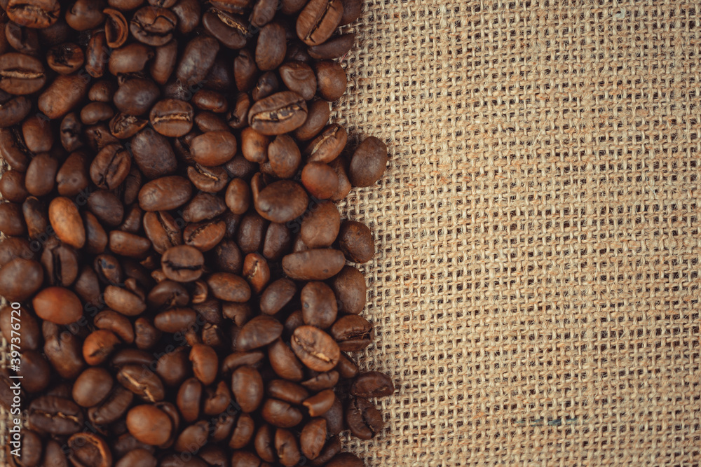 Roasted coffee beans on burlap. Background for coffee shops and store websites Roasted coffee beans on burlap. Background for coffee shops and store websites