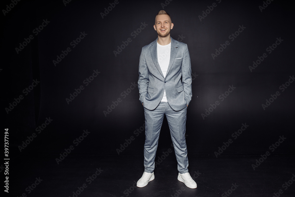 Full length body size photo of man wearing grey classy suit smiling cheerful isolated on black color background