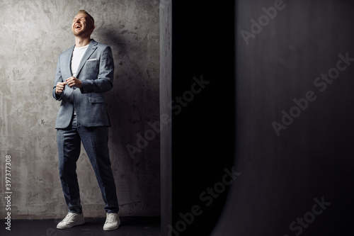 Full length body size photo of happy dancing at party man laughing wearing fashionable grey suit smiling relaxing on weekend