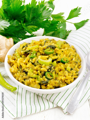 Kitchari with celery in bowl on white board photo