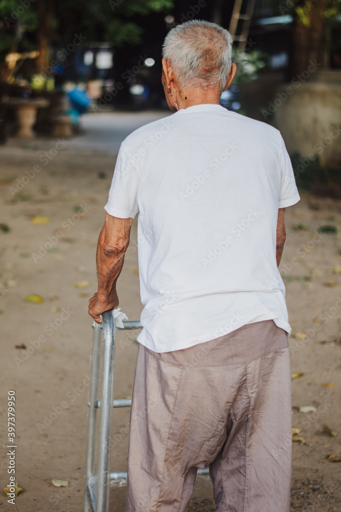 Close up image of old Asian man with walking frame in park. Close up image of old Asian man with walking frame in park.