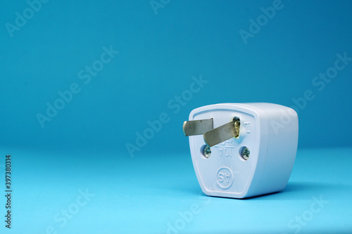 Broken Adapter plug on blue background - Power electrical converter Concept - Object isolated   photo