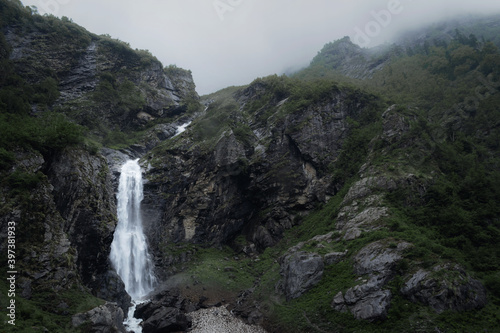 Moody Waterfall in the green mountains covered in mist