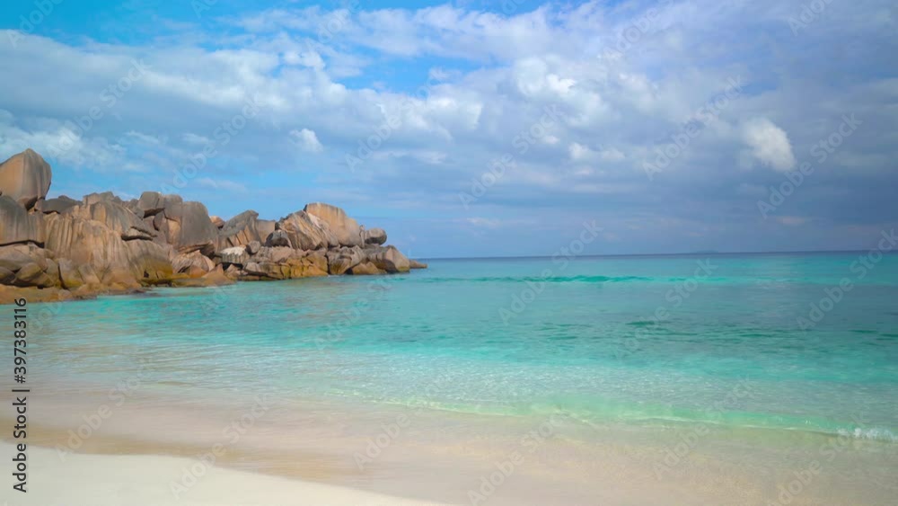 Exotic beach by the ocean with rolling waves on the sandy shore and blue sky Exotic beach by the ocean with rolling waves on the sandy shore and blue sky