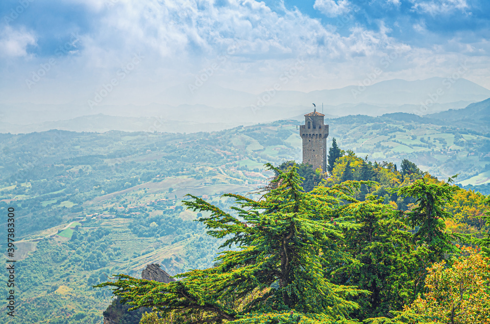 Republic San Marino Terza Torre Montale third fortress tower with brick walls on Monte Titano stone rock with green trees, aerial top panoramic view of landscape valley and hills of suburban district
