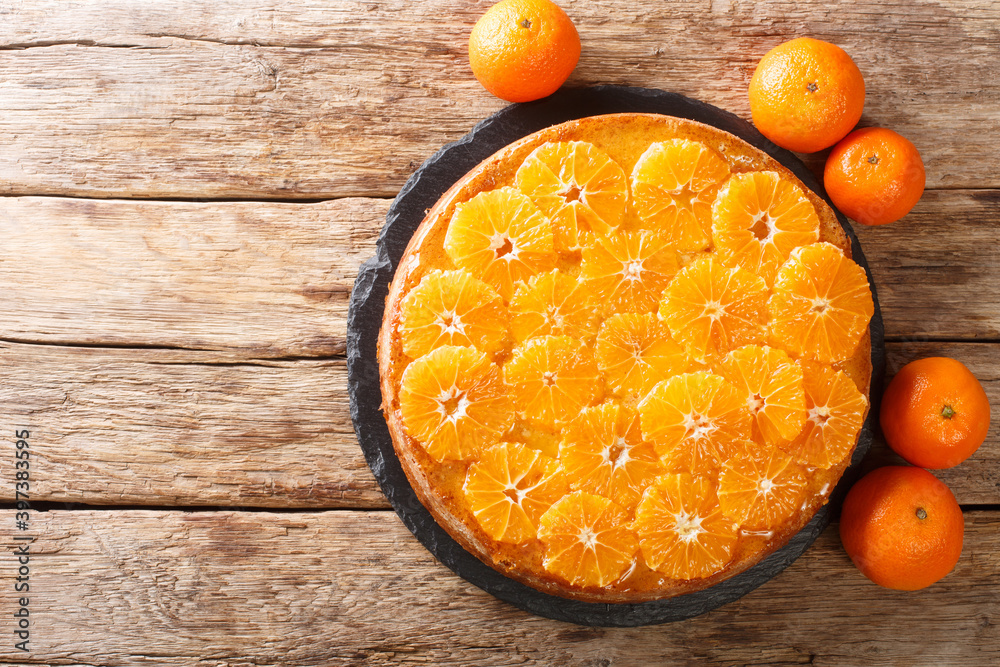 Fresh fruit tangerine pie close-up on a slate board on the table. horizontal top view from above Fresh fruit tangerine pie close-up on a slate board on the table. horizontal top view from above
