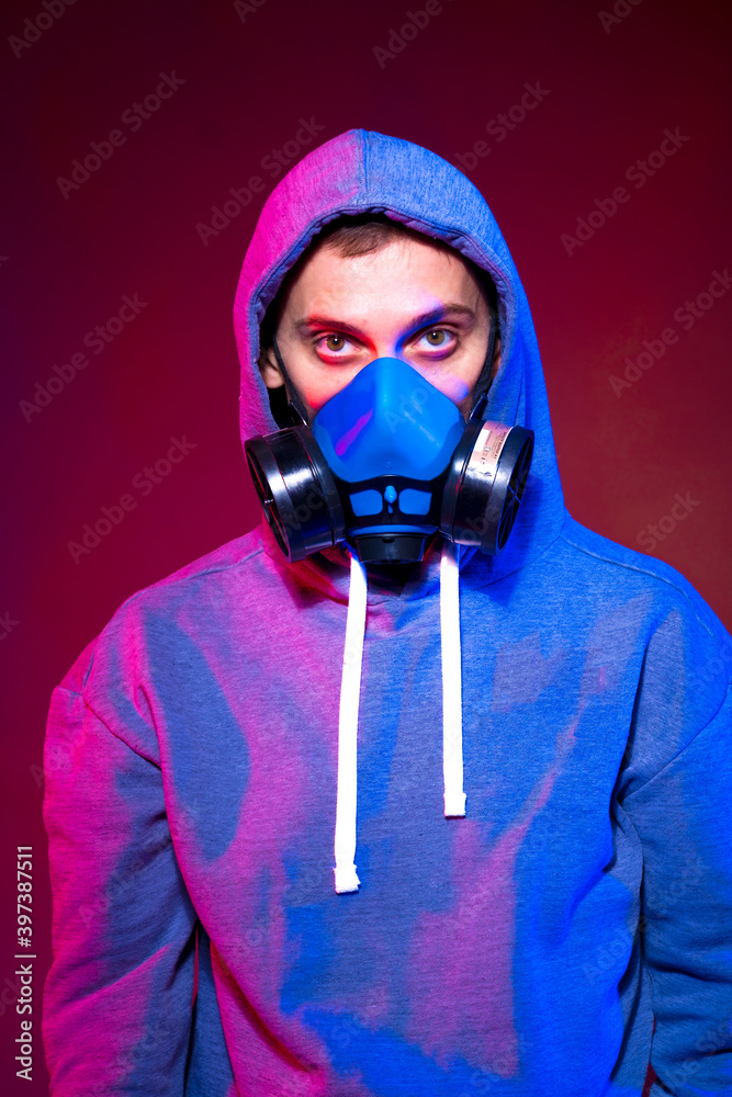Portrait of an anonymous man, hacker wearing neon mask over dark background. Selective focus of bi-racial cyberpunk player holding guns near neon lighting Portrait of an anonymous man, hacker wearing neon mask over dark background. Selective focus of bi-racial cyberpunk player holding guns near neon lighting