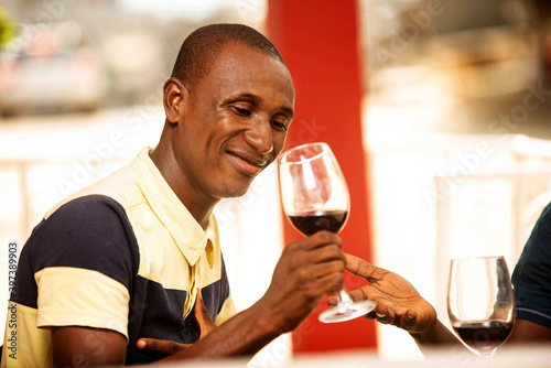 handsome young man drinking a glass of red wine