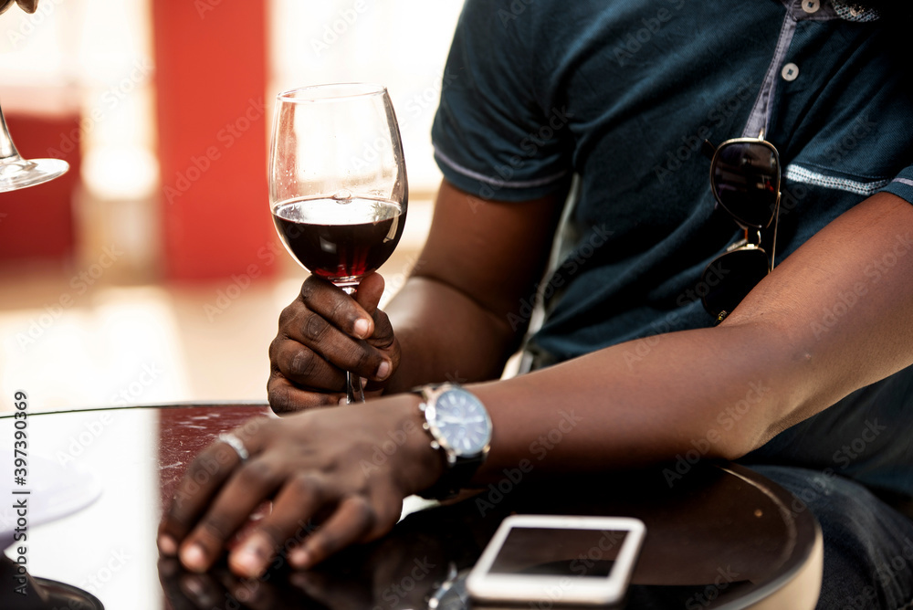 young man sitting in an open air holding a glass of red wine