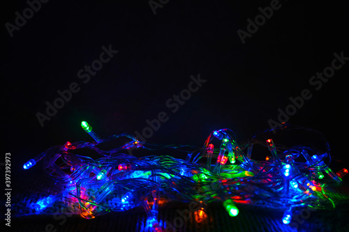 Glowing Christmas lights on a dark background. 