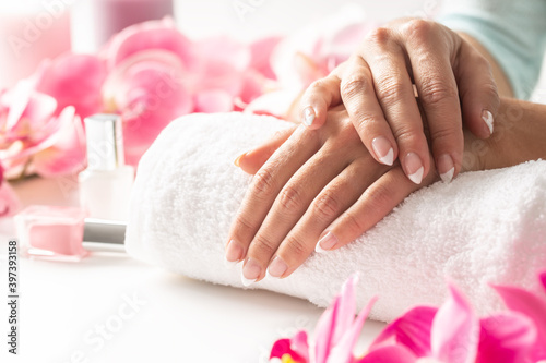 Relaxed hands of a woman placed on a towel awaiting her manicure to be done and nail polish applied