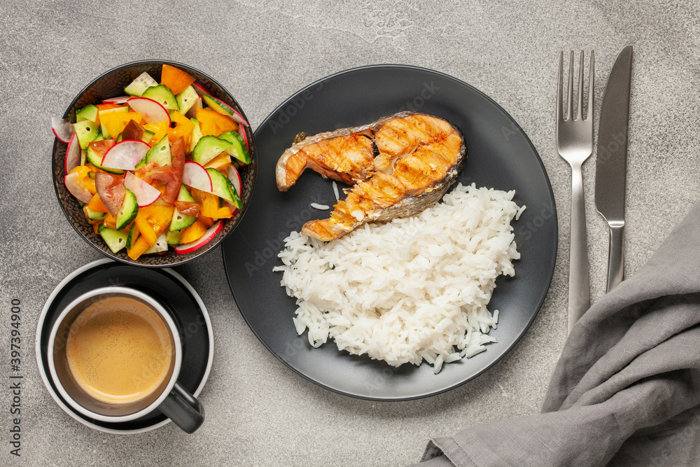 Fish salmon grill with rice and vegetables on a plate on the table. Top View Fish salmon grill with rice and vegetables on a plate on the table. Top View