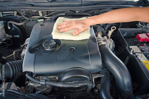 Hand cleaning car engine with a rag,worker