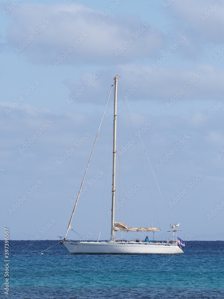 SANTA MARIA, CAPE VERDE on MARCH 2019: White yacht at Atlantic Ocean landscapes at african Sal island with horizon line and clear blue sky in warm sunny summer day - vertical.