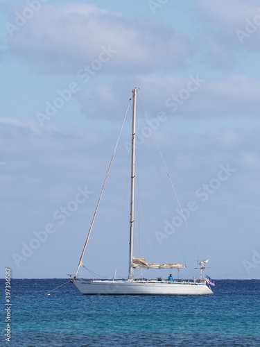 SANTA MARIA, CAPE VERDE on MARCH 2019: White yacht at Atlantic Ocean landscapes at african Sal island with horizon line and clear blue sky in warm sunny summer day - vertical.