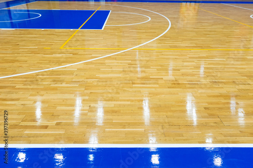 Top view of a part of an empty basketball court. the floor of the sports space is made of wood and painted blue © vetaka
