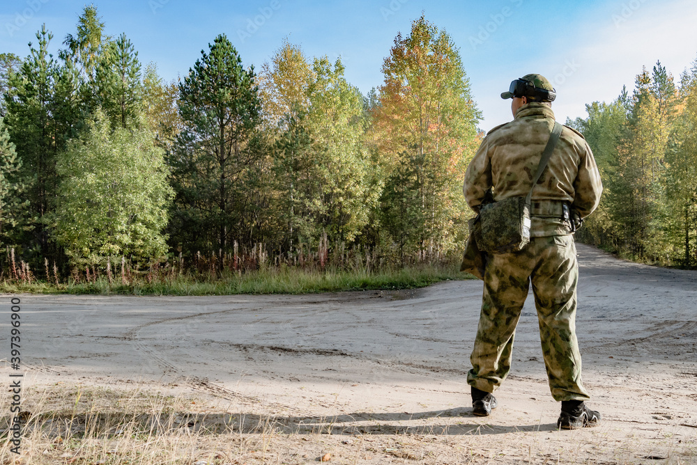 Soldier at the intersection of dirt roads in the forest in uniform Soldier at the intersection of dirt roads in the forest in uniform