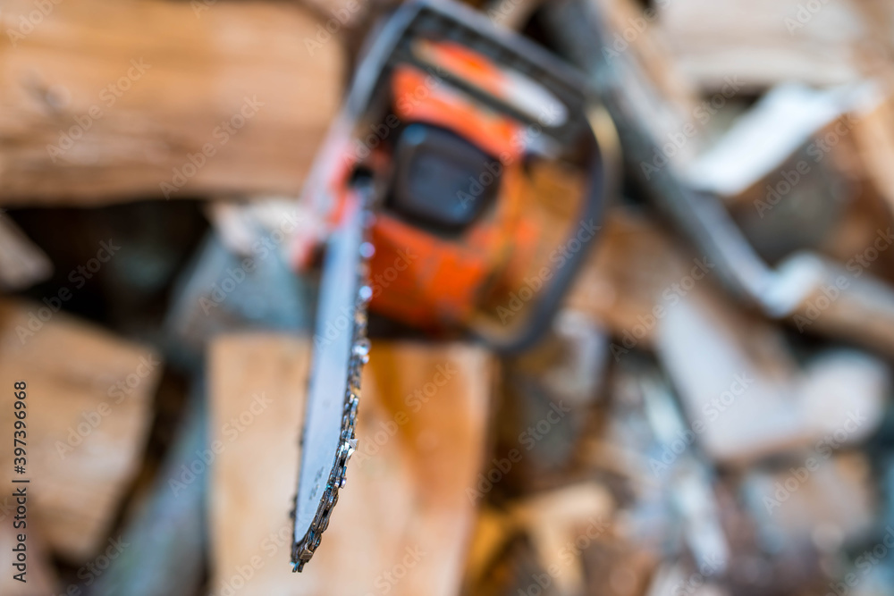 Sharp chain on used chainsaw, shallow depth of field, space for text.