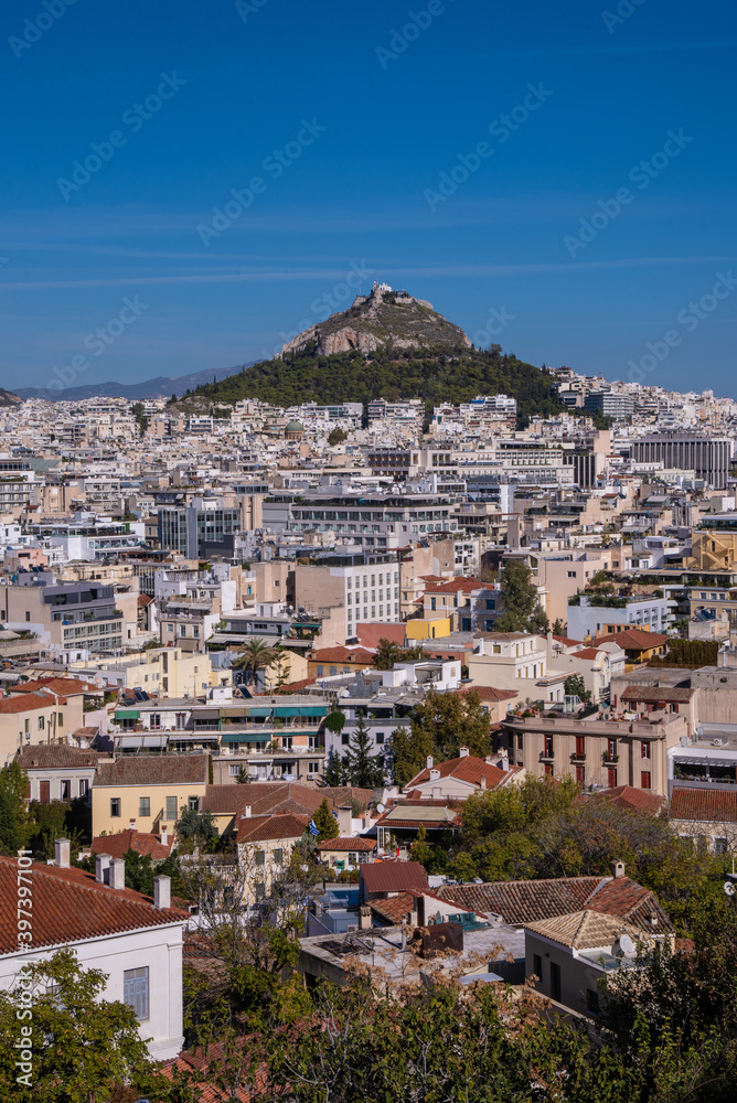 Beautiful scenic city view of Athens with Acropolis hill, Greece. Famous Acropolis is the main landmark of Athens. Landscape photo of Athens city from above shot from viewpoint on a sunny summer day.