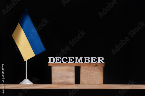 Wooden calendar of December with Ukrainian flag on black background. Dates in Ukraine in December.