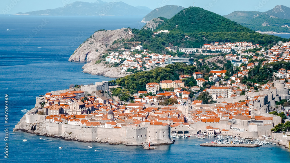 Aerial view of Old Port and Dubrovnik Old Town.  Dubrovnik town and its city walls with mountains in the background
