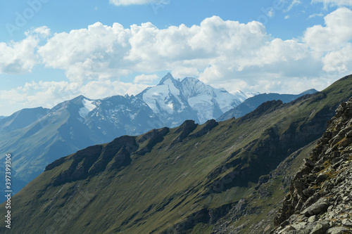 Panoramic view from Hohe Sonnblick in Austrian Alps on Gro?glockner. The whole area is very steep and dangerous, with many lose stones. Green, steep meadows in front. Sunny day. Expedition