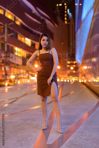 Full length shot of beautiful Asian woman outdoors in Bangkok, Thailand at night © Ranta Images