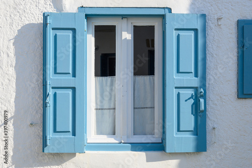 Traditional Greek window with blue shutters in beautiful Chora town on Folegandros island, Cyclades islands, Greece
