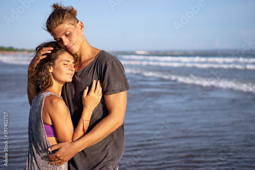 Love and romance. Honeymoon on the sea shore. Beautiful loving couple embracing on the beach.