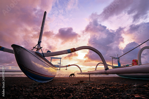 Beautiful sunrise. Ocean, beach and indonesian fishing boats.